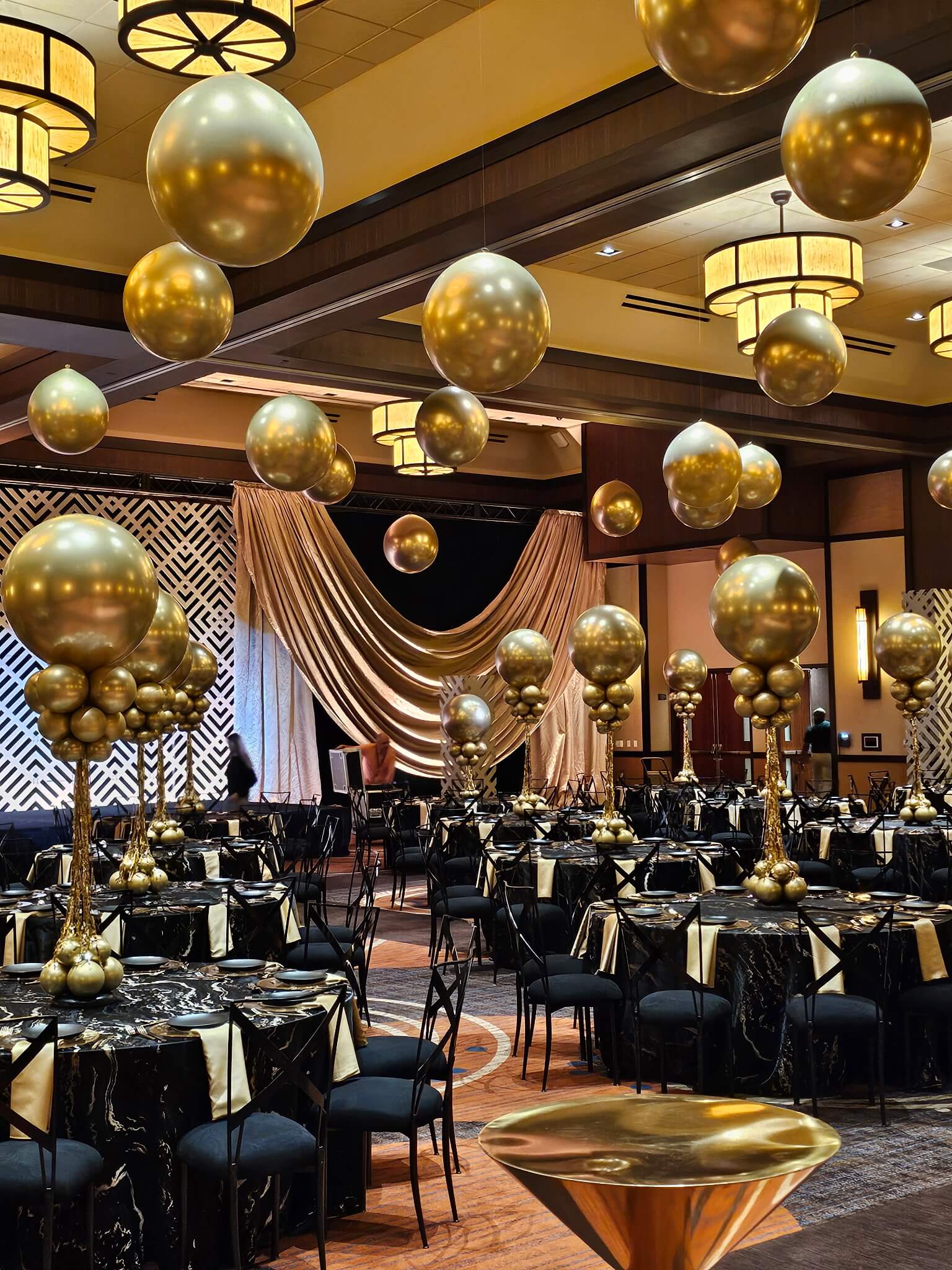 New years Eve gold centerpieces and gold ceiling balloons for a ballroom