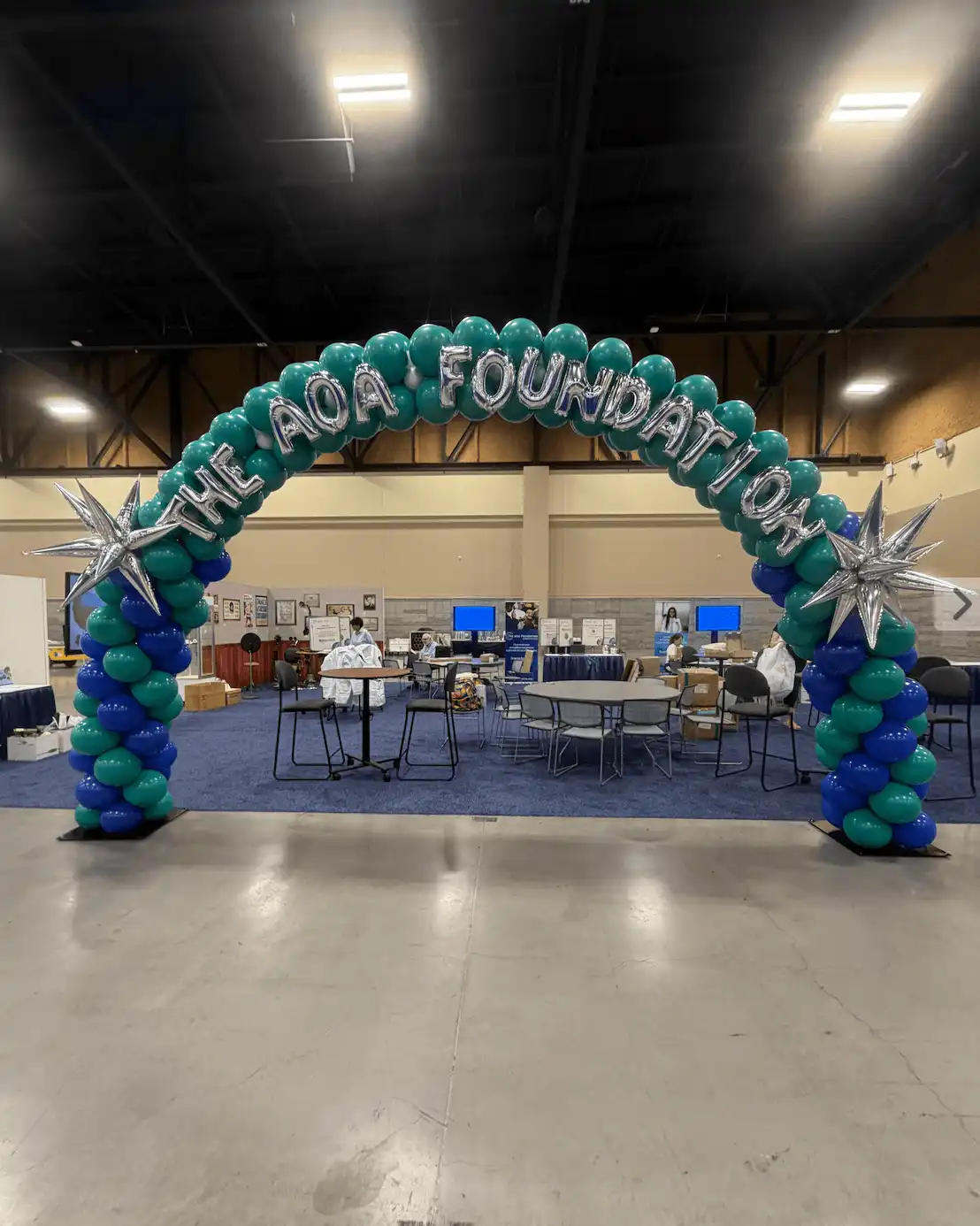 Balloon arch with text at a convention booth