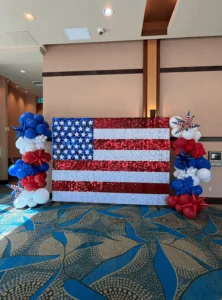 USA flag shimmer wall with patriotic balloon garland columns